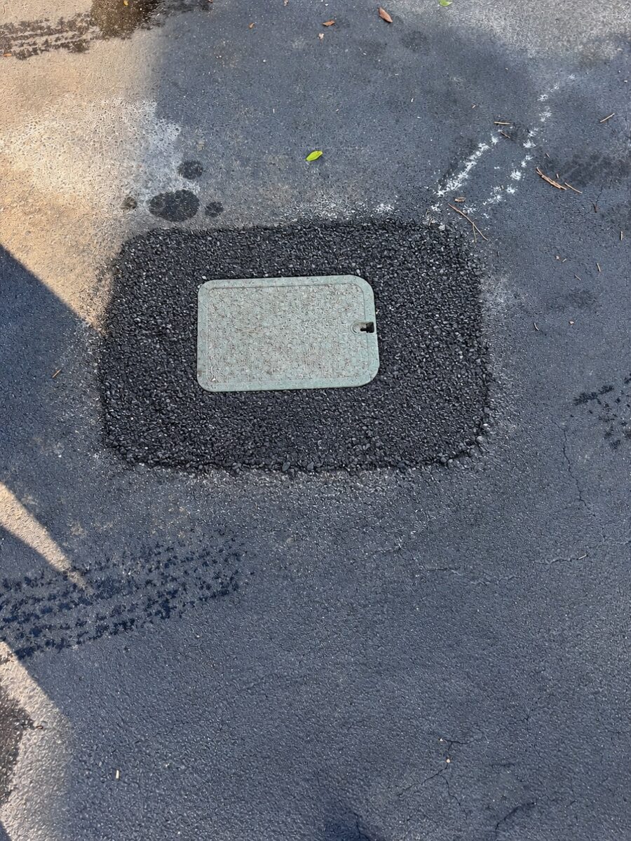 Clean cold patch worked around a utility access box
